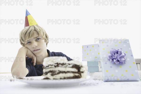 Tired young boy at a birthday party. Photo. momentimages