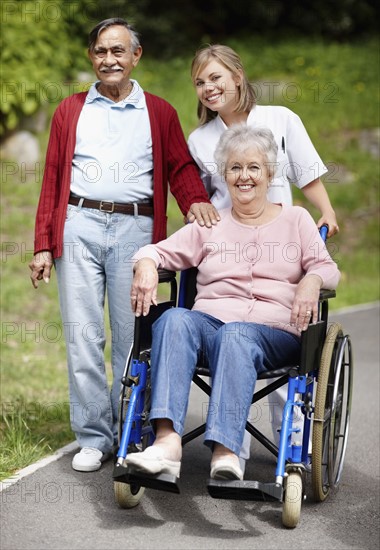Nurse pushing senior woman in a wheelchair. Photo. momentimages