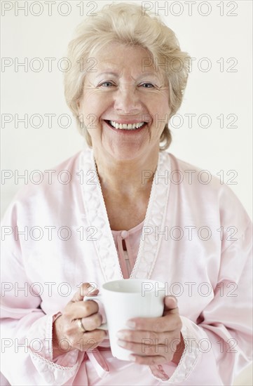 Senior woman wearing a bathrobe. Photo. momentimages