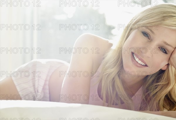Pretty blond relaxing on bed. Photo. momentimages