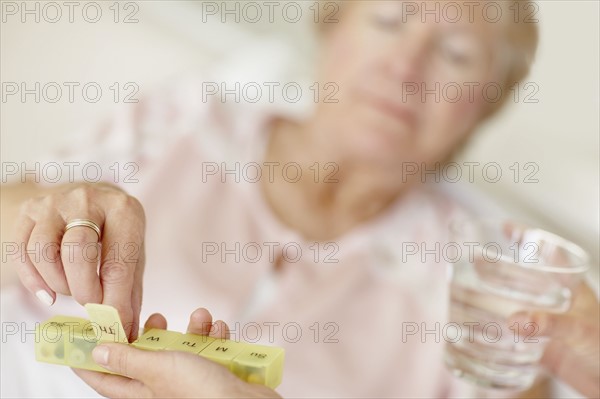 Nurse giving pill to senior woman. Photo : momentimages