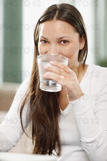 Woman drinking a glass of water. Photo. momentimages