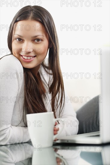 Woman drinking coffee while browsing the internet. Photo : momentimages