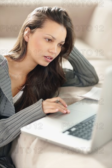 Woman concentrating while looking at computer. Photo : momentimages