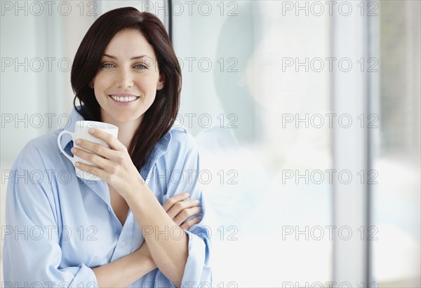 Attractive brunette drinking coffee. Photo : momentimages