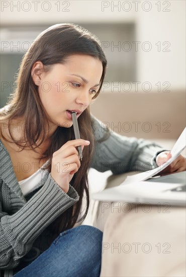 Woman concentrating while doing paperwork. Photo. momentimages