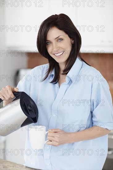 Brunette woman pouring coffee. Photo. momentimages