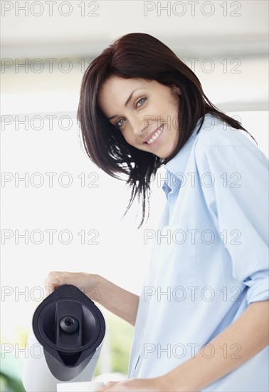 Brunette woman pouring coffee. Photo. momentimages