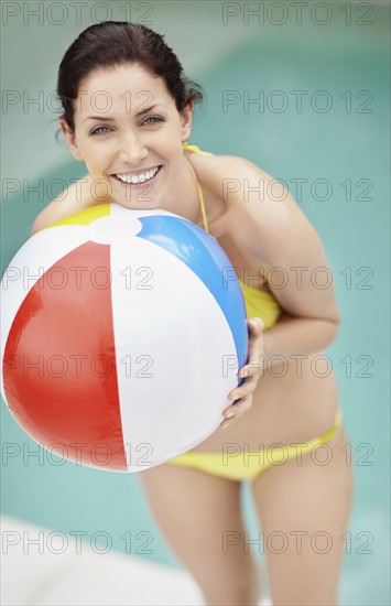 Attractive brunette holding a beach ball. Photo. momentimages