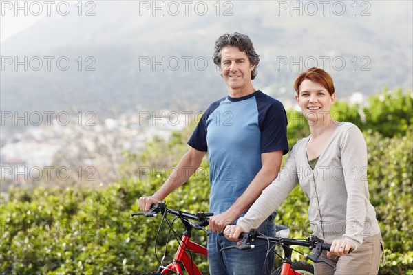 Cyclists standing beside their bikes. Photo. momentimages