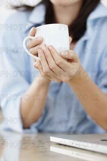 Brunette woman drinking coffee. Photo. momentimages