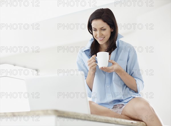 Brunette woman browsing the internet. Photo : momentimages