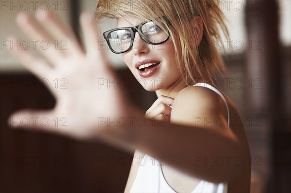 Blond woman holding her hand out. Photo : momentimages