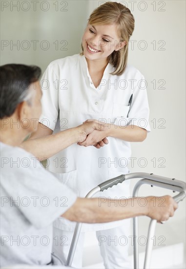 Nurse assisting patient with a walker. Photo. momentimages