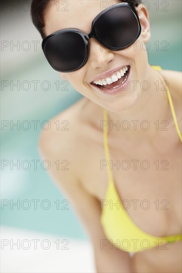 Smiling woman wearing bikini and sunglasses. Photo. momentimages