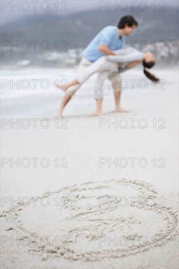 Playful couple at the beach. Photo : momentimages