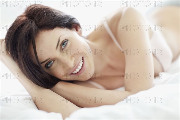 Sexy woman lying on bed. Photo : momentimages