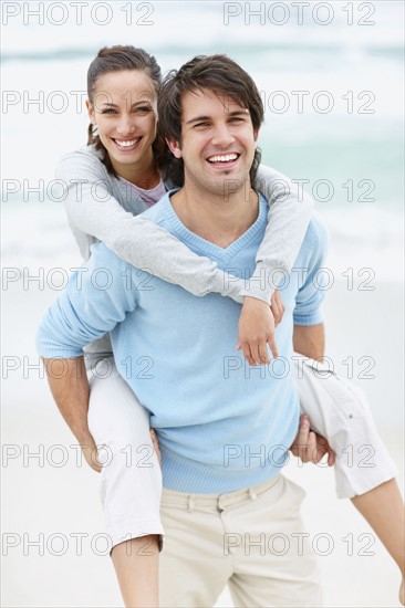 Man giving woman a piggy back ride. Photo. momentimages