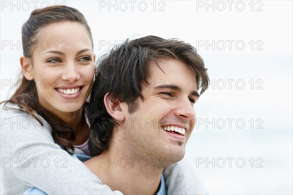 Man giving woman a piggy back ride. Photo. momentimages