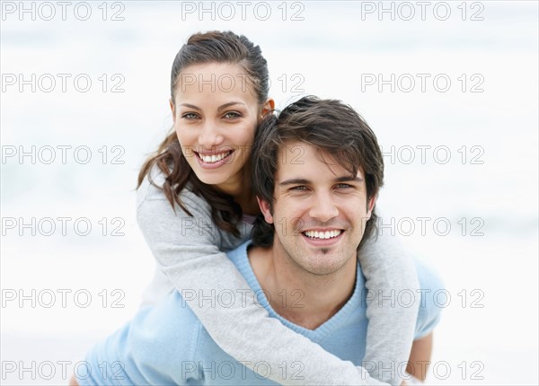 Man giving woman a piggy back ride. Photo. momentimages