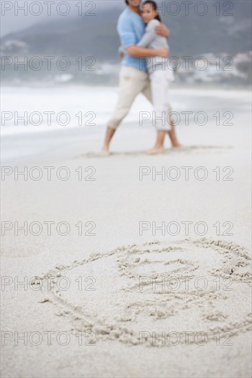 Couple embracing at the beach. Photo : momentimages