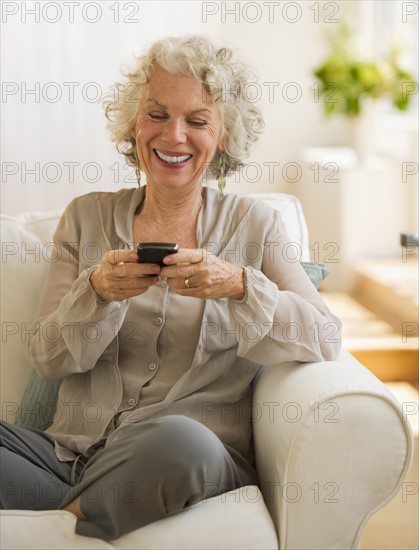 Cheerful woman texting. Photo : Daniel Grill