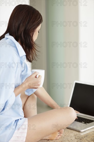 Brunette woman browsing the internet. Photo : momentimages