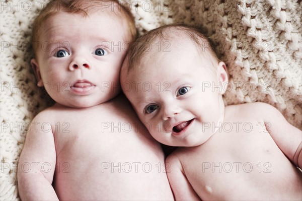 Two babies lying together. Photo : Jamie Grill