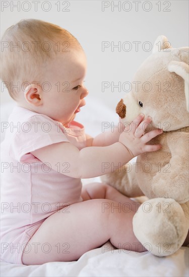 Baby playing with teddy bear. Photo. Jamie Grill