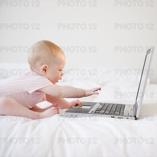 Baby playing with laptop. Photo : Jamie Grill