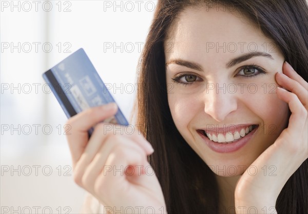 Young woman holding a credit card. Photo. Jamie Grill