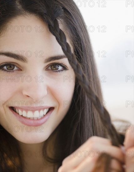 Young woman braiding her hair. Photo. Jamie Grill