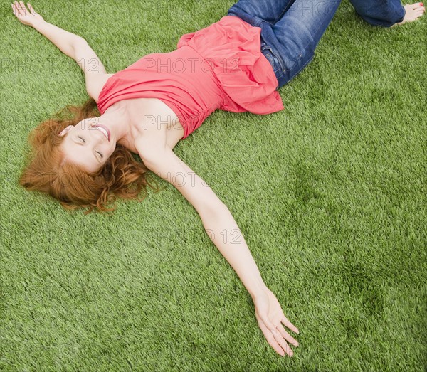 Beautiful woman relaxing on grass. Photo : Jamie Grill