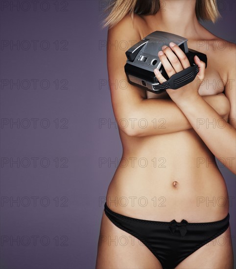 Sexy woman holding a camera. Photo. momentimages