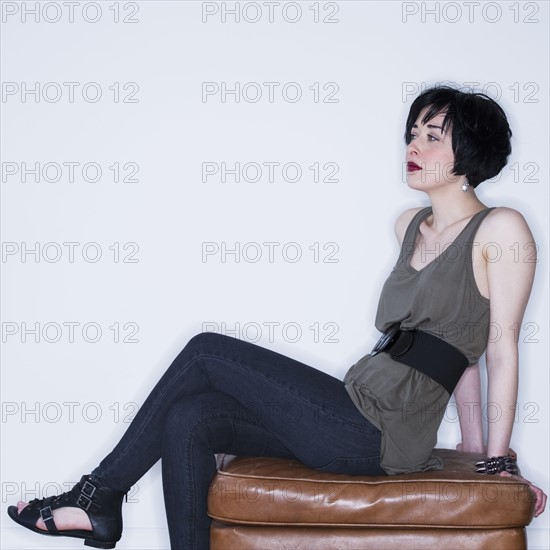 Woman sitting on ottoman. Photo : Daniel Grill