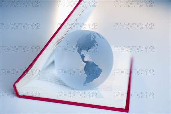 Globe inside a book.