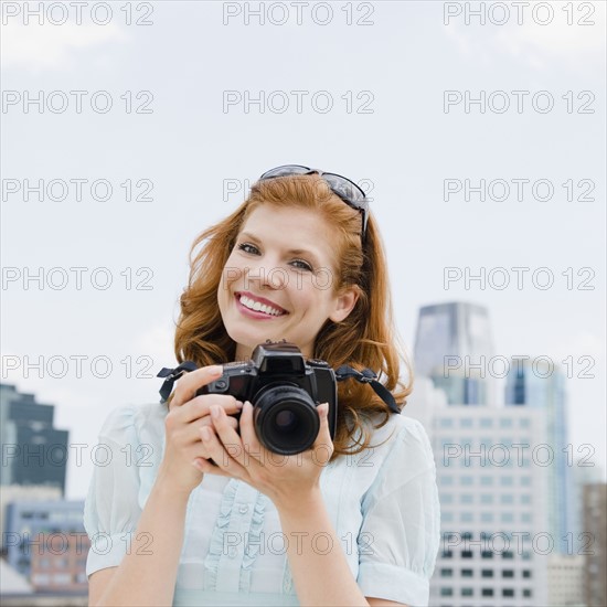 Woman taking a photograph. Photo : Jamie Grill