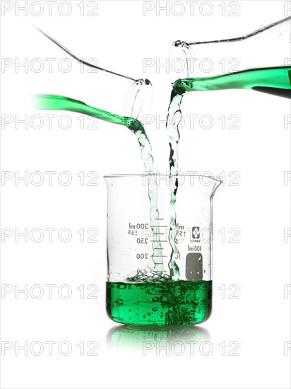 Green liquid being poured into measuring cup. Photo. David Arky