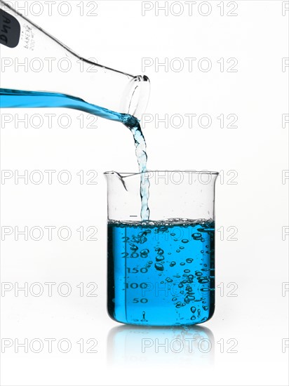 Blue liquid being poured into measuring cup. Photo : David Arky