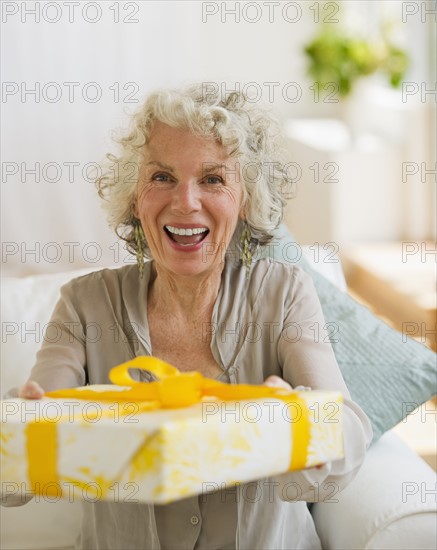 Surprised woman receiving a birthday gift. Photo. Daniel Grill