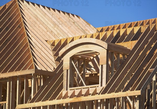 Roof framing of partially built house. Photo : fotog