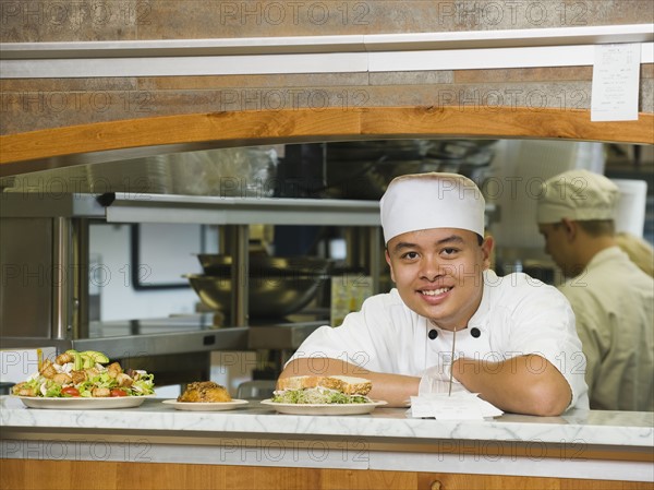 Chef leaning on counter.