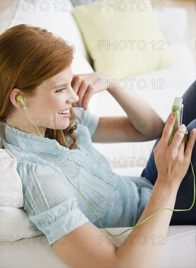 Woman listening to music on Mp3 player. Photo : Jamie Grill