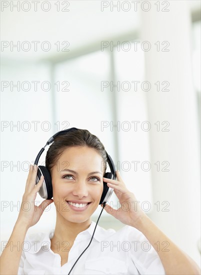 Woman listening to music on headphones. Photo. momentimages