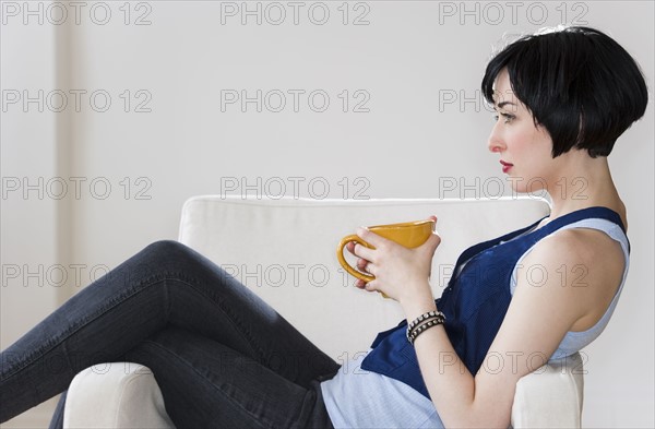 Woman relaxing with cup of coffee. Photo : Daniel Grill