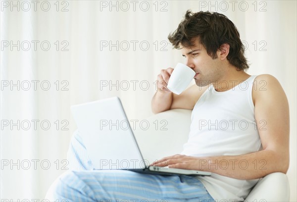 Relaxed man browsing the internet. Photo : momentimages