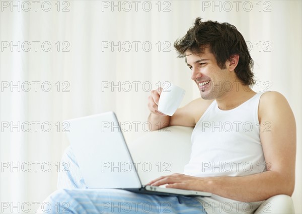 Relaxed man browsing the internet. Photo : momentimages