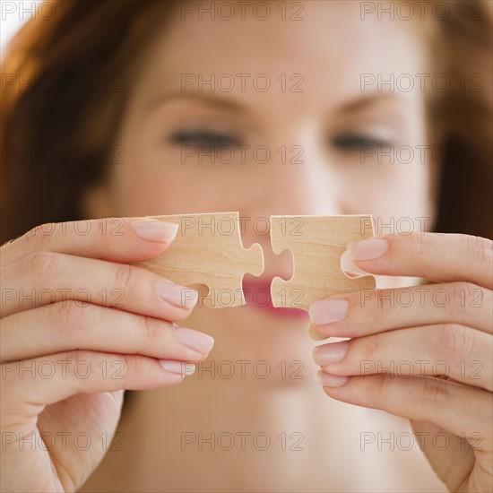 Woman putting puzzle pieces together. Photo : Jamie Grill