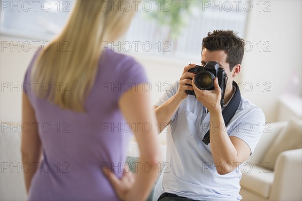 Man taking photograph of woman.