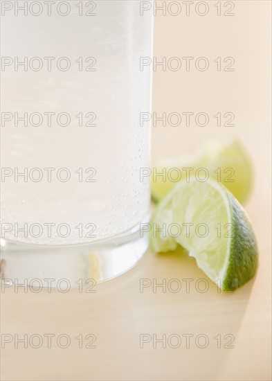 Slices of lime beside glass of water. Photo : Jamie Grill